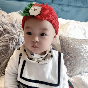 Nahaufnahme eines roten Strick-Stirnbands für Babys mit glitzerndem Weihnachtsmann-Motiv