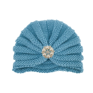 Détail du tricot d'un bonnet turban bleu pour bébé avec boucle fleur en perles et strass
