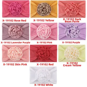 Detail of soft nylon baby headbands featuring large handmade fabric ribbon roses in ten colors