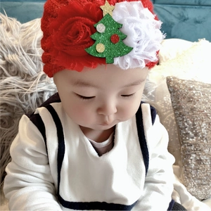 Detailaufnahme Baby Stirnband mit Spitzenblumen und glitzerndem grünem Weihnachtsbaum
