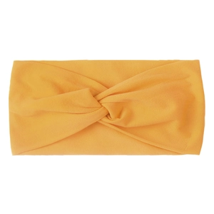 Macro shot of ginger yellow knotted nylon hair band with soft ribbed elastic texture