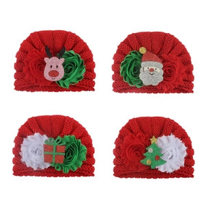 Detailansicht von vier roten Baby-Strickmützen mit festlichen 3D-Weihnachtsfiguren für Kinder