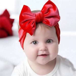 Détail du bandeau à double nœud en velours rouge pour bébé avec une texture douce
