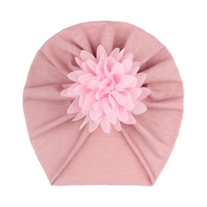 Détail du bonnet turban rose pour bébé avec une grande fleur en tissu 3D sur tricot doux