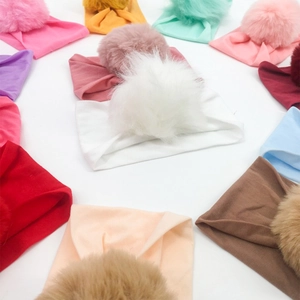 Elastic nylon baby headbands with large faux fur pompoms in multiple vibrant colors