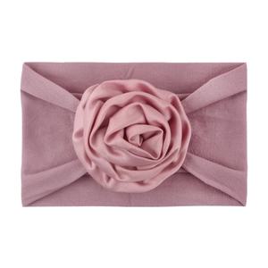 Close-up of dusty rose nylon baby headband with a handcrafted satin ribbon rosette