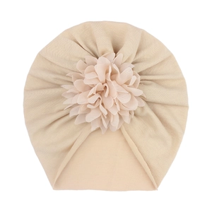 Détail du bonnet turban pour bébé beige orné d'une grande fleur en mousseline de soie douce