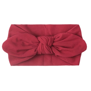 Detail of soft nylon baby headband with a dark red rabbit ear bow design