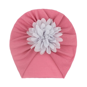 Détail du turban rose pour bébé avec une grande fleur en mousseline blanche multicouche