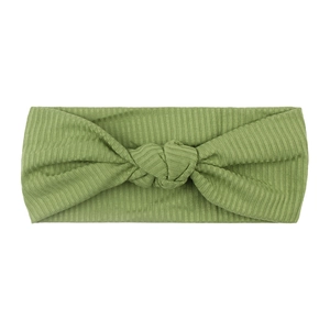 Green ribbed knit elastic headband for baby with cute knot center on white background