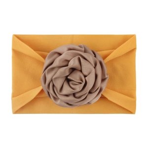 Detail of soft nylon infant headband with a large layered coffee brown satin flower