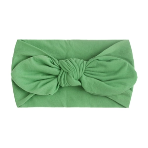 Detail view of grass green baby turban with a soft knit fabric and knotted bunny ear bow