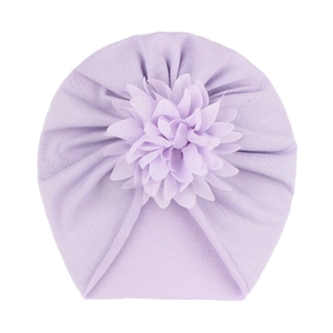 Détail d'un turban pour bébé avec une grande fleur en mousseline sur maille violet clair