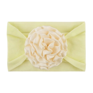 Detail showing the creamy yellow handmade ribbon flower on a soft nylon baby headband