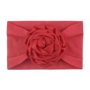 Close-up of soft red nylon baby headband featuring a large 3D fabric rose flower detail