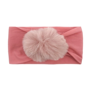 Detailed view of pink elastic nylon baby headband with a large soft faux fur pompom decor