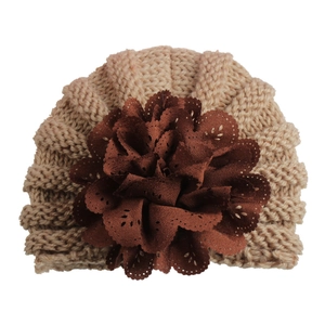 Detailed view of baby turban hat with large brown fabric flower and knit texture