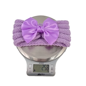 Detail of purple knitted baby headband showing texture and large satin bow weighing 25.8 grams