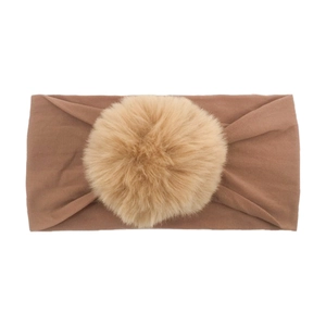 Detailed macro view of the soft brown nylon baby headband with a fluffy brown pom pom