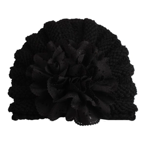 Detailed close-up of a black baby knit turban hat featuring a hollow-out floral decoration