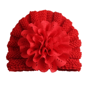 Close-up of red baby knit hat featuring a large layered floral petal decoration