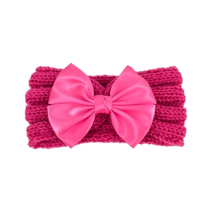 Detailed view of the rose red knitted baby headband featuring a large satin bow accent