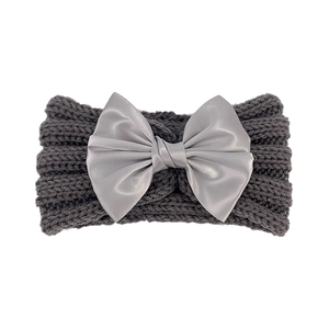 Detailed texture of charcoal knit baby headband with silver satin bow on white background