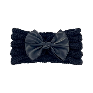 Detailed view of the black knitted baby headband with a large matching satin bow