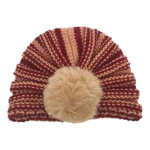 Dettaglio della trama a righe a maglia grossa e del pompon in finta pelliccia sul cappello bimbo