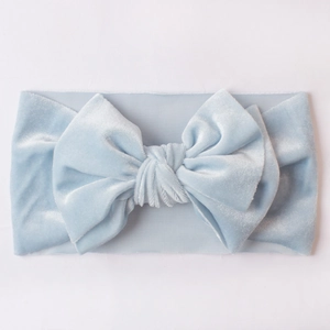 Detail van baby lichtblauwe fluwelen hoofdband met een grote strik en zachte textuur