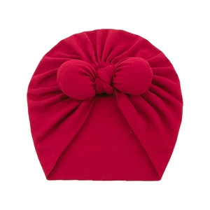 Soft dark red baby turban hat with a large bow detail for infant girls on white background