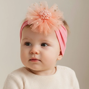 Detail von rosa Baby-Stirnband mit Mesh-Blumenverzierung und goldener Stern-Stickerei
