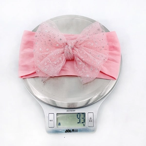 Detailed view of lightweight 9.3g pink nylon bow headband on a digital scale