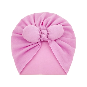 Detail of soft knit pink baby turban hat with a large decorative front bow