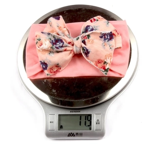 Gros plan montrant le bandeau floral léger de 11,9g pour bébé sur une balance