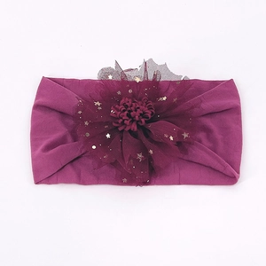 Detail von burgunderfarbenem Baby-Haarband mit Netzblumen und goldenen Sternen auf Nylon