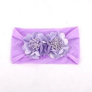 Close-up of soft purple elastic baby headband with two decorative fabric flowers