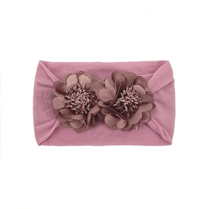 Close-up of stretchy mauve baby headband with dual layered handmade fabric flowers