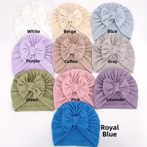 Flat lay showing ten color options of baby turban hats with large bows and elastic texture