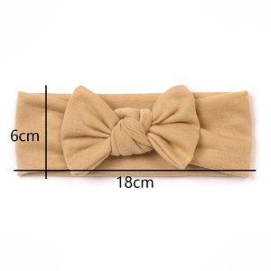 Detail shot of khaki knitted infant headband featuring a large bow and 18x6cm dimensions