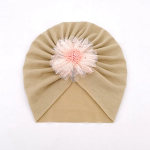 Détail d'un turban pour bébé kaki avec une fleur décorative en maille rose empilée