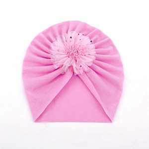 Détail d'un bonnet turban rose pour bébé avec fleur en résille et paillettes étoilées