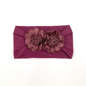 Close-up of deep plum baby headband featuring two handcrafted large floral ornaments