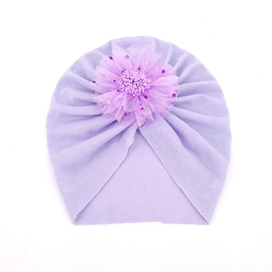 Détail du turban pour bébé en tissu plissé respirant avec une fleur en mesh violet