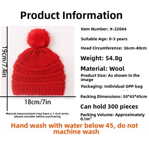 Detail of red knitted baby hat for ages 0-3 with pompom and ribbed texture specs