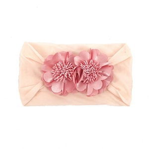 Close-up of soft pink baby headband with detailed twin handmade fabric flowers on band