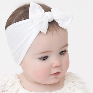 Nahaufnahme des weißen Baby-Haarbandes aus Nylon mit weicher Textur und großer Schleife