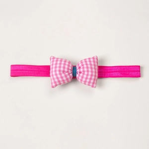 Detailed view of magenta elastic baby headband featuring a pink checkered bow accent