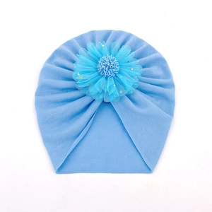 Détail du bonnet turban bleu ciel pour bébé avec fleur en résille et étoiles dorées
