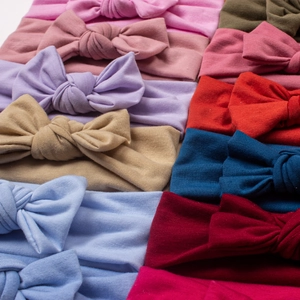 Macro detail of wide soft knit cotton baby headbands in multiple solid color options